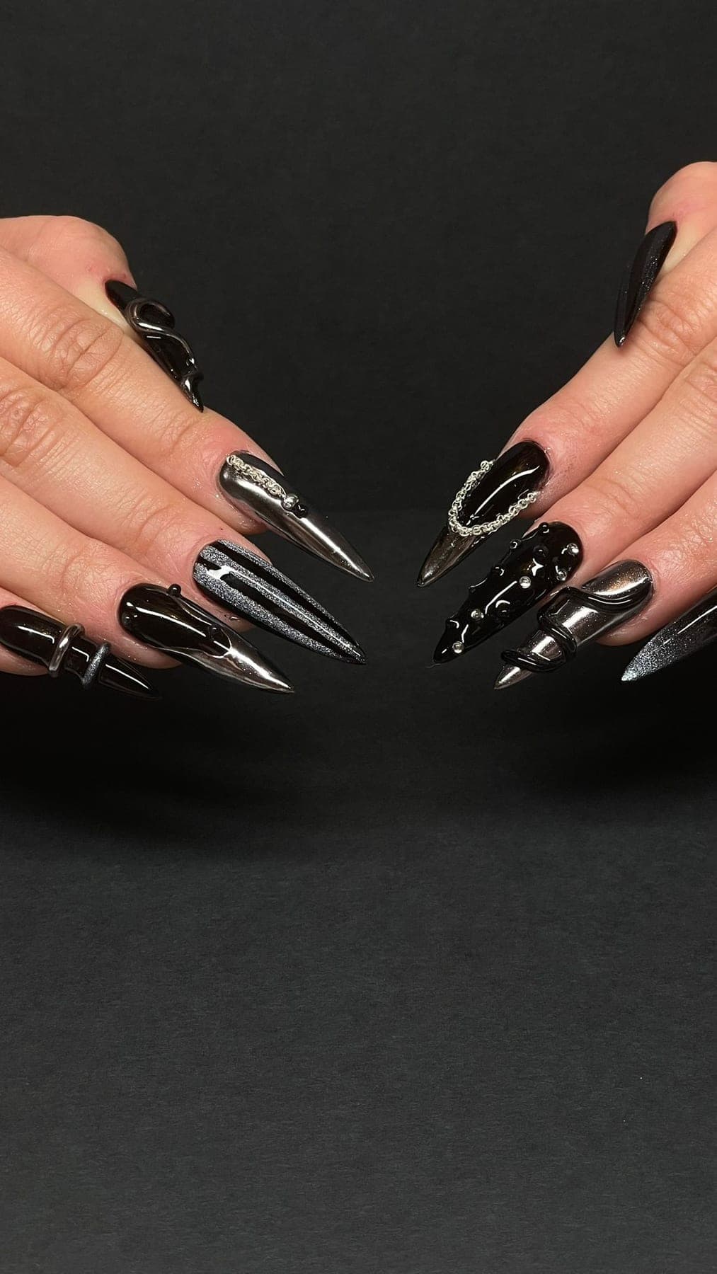 Stiletto noir brillant avec chaînes argentées et strass dramatiques.