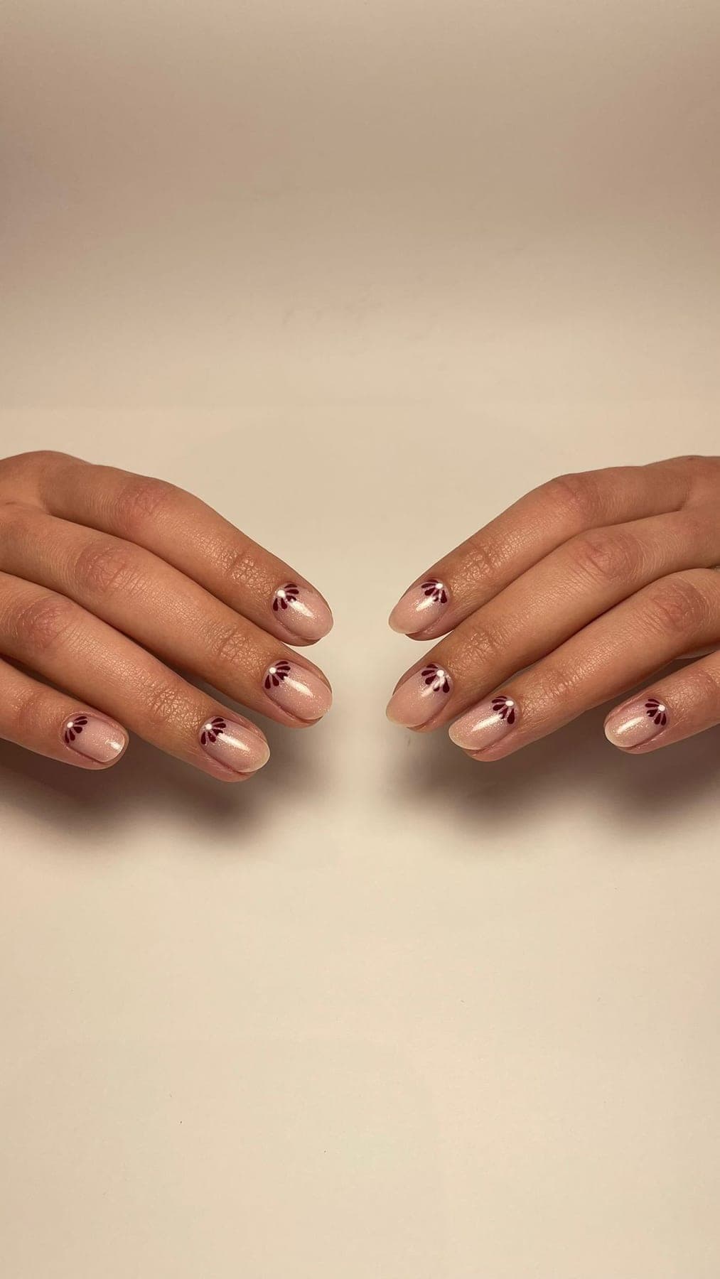 Nude rose perlé avec petites feuilles bordeaux discrètes.
